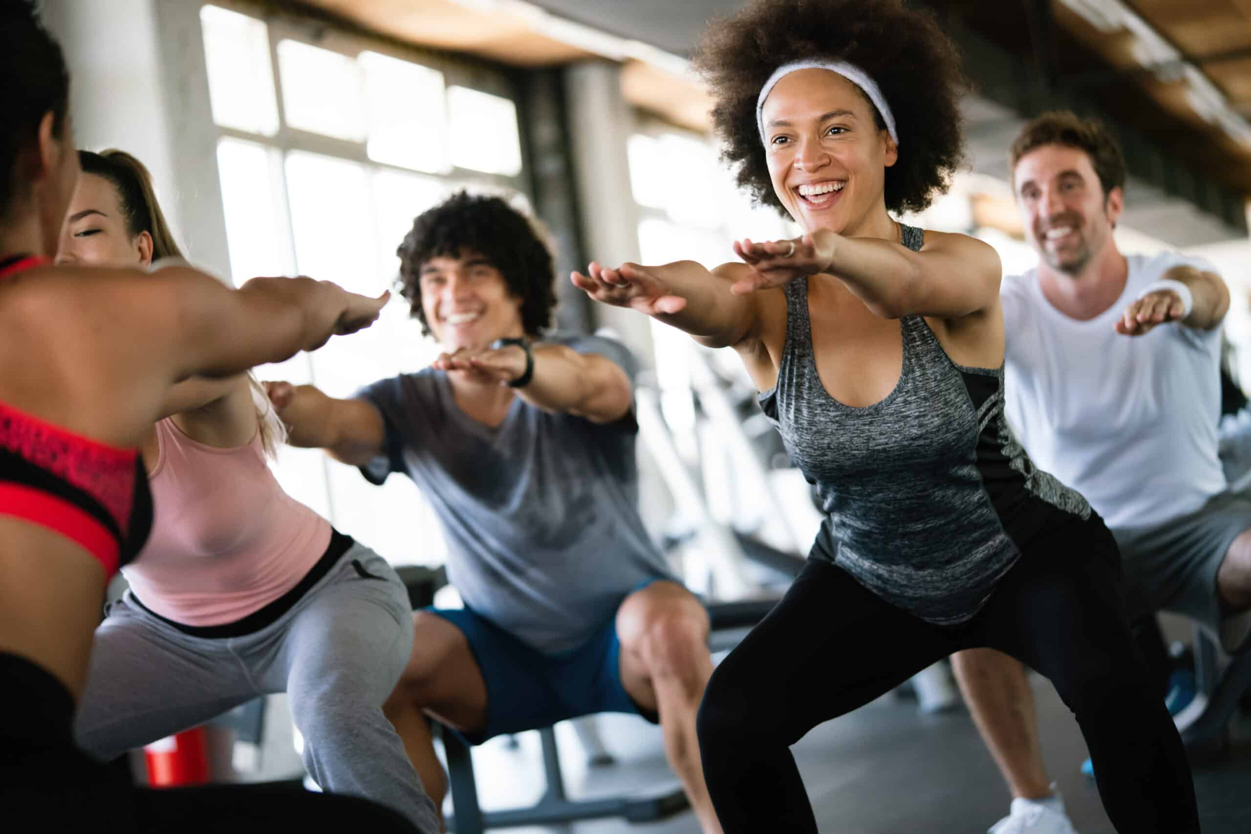 Appareils elliptiques Precor et salle de sport moderne Intérieur de salle de sport avec plusieurs elliptiques Precor modernes gris et noirs ; une horloge murale est visible sur un mur de briques rouges.